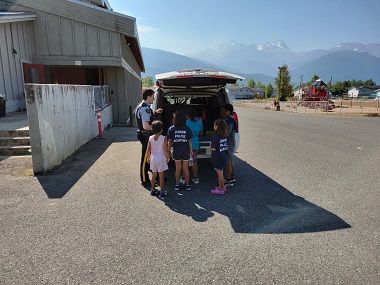 Des cadets regardent l’intérieur d’un véhicule de police 