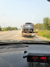 Looking through police car windshield with radar unit in foreground and vehicle in background