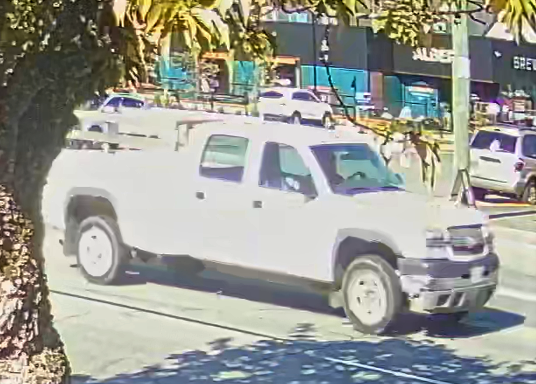 A white Chevrolet pickup truck with stake side bed.