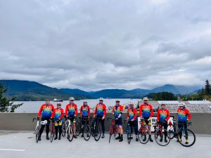 Tour de North riders pose with their bikes in front of the Prince Rupert Harbour