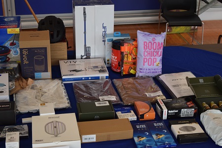 Various stolen items laid out on a table with a blue table cloth, including cleaning items and junk food.