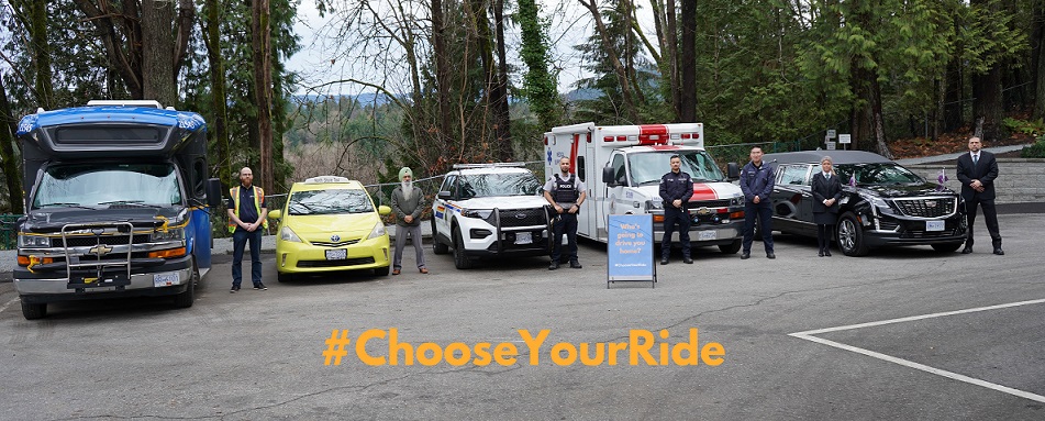 Bus and bus driver, taxi and a driver, police car and an officer, ambulance and a ambulance vehicle and a hearse standing all standing with a board that states "who's going to drive you home? #ChooseYourRide"