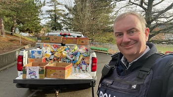 police pick up truck filled with donation next to a police officer