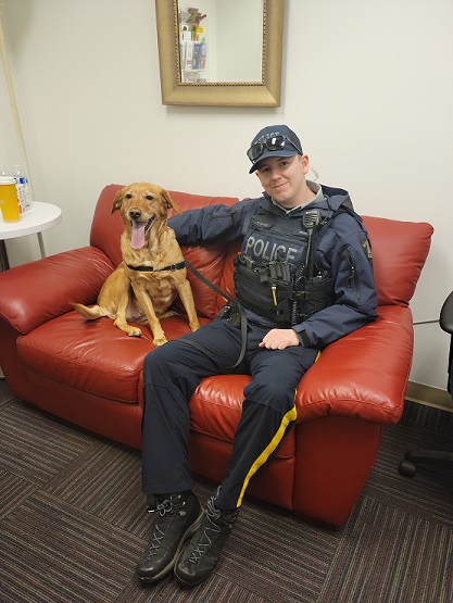 Un agent du Détachement de la GRC de North Vancouver est assis avec Amber, le golden retriever, volée à l’extérieur d’un commerce dans le secteur de Lonsdale.